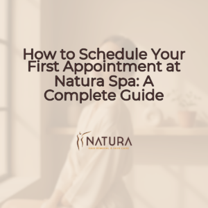 A woman with glowing skin, elegant posture, and a genuine confident smile is touching her face. The background is softly blurred with warm beige, cream, and soft brown tones, creating a luxurious and natural spa-like atmosphere.