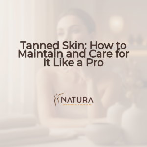 A woman with glowing skin, soft makeup, and a confident smile, touching her face in a relaxed pose.