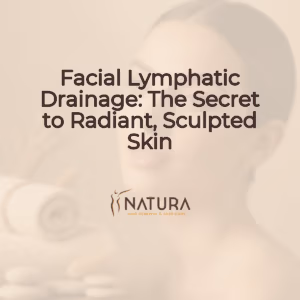 A woman with radiant skin, natural makeup, and a confident smile, gently touching her face. Soft, diffused lighting highlights her features against a blurred background in warm beige, cream, and soft brown tones.