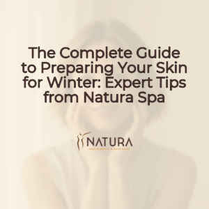 A serene female model with natural glowing skin, short hair, and a confident smile, in a relaxed pose, with a blurred soft, warm, natural background.