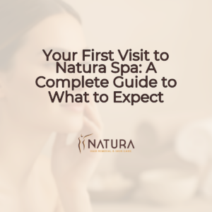 A serene female model with natural glowing skin, relaxed and contemplative, her gaze suggesting inner peace, against a soft, blurred background in warm, natural tones, embodying the luxurious and tranquil mood of Natura Spa. The lighting is soft and diffused, highlighting a confident smile.