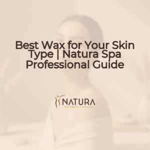 A woman with glowing skin, with a genuine, confident smile, poses in a relaxed manner with her hands near her face. The background is softly blurred.