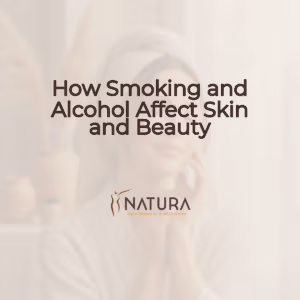 A woman with glowing skin in a relaxed spa pose, touching her face with a genuine confident smile. The image has a soft, warm, natural aesthetic with blurred background.