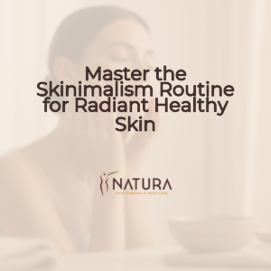 A woman with glowing skin touching her face, captured with soft, diffused lighting against a blurred, warm-toned background.