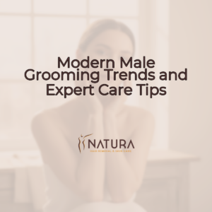 A woman with a relaxed and confident smile, touching her face, suggesting the benefits of good skincare. The background is softly blurred with warm, natural tones, evoking a luxurious and spa-like atmosphere.