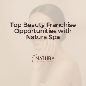 A woman with glowing skin is in a relaxed spa pose, touching her face with a genuine confident smile. The background is softly blurred.
