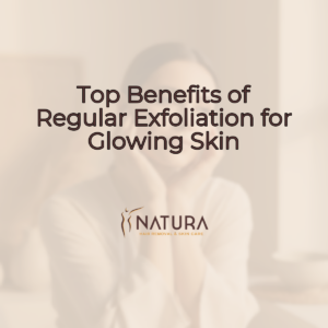 A close up of a woman's face, with a soft, natural glow, against a blurred, warm background, representing the benefits of exfoliation.