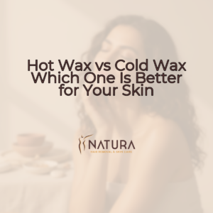 A woman with naturally glowing skin, a genuine smile, in a relaxed pose with natural lighting. She is touching her face or engaging in a skincare routine with a slightly blurred background in warm beige/cream/soft brown tones.
