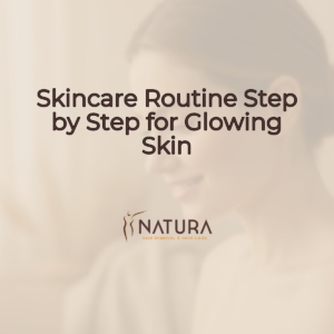 A woman with glowing skin touching her face, set against a blurred, warm background.